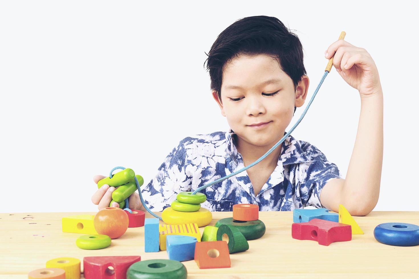 Lovely asian boy is play colorful wood block toy photo