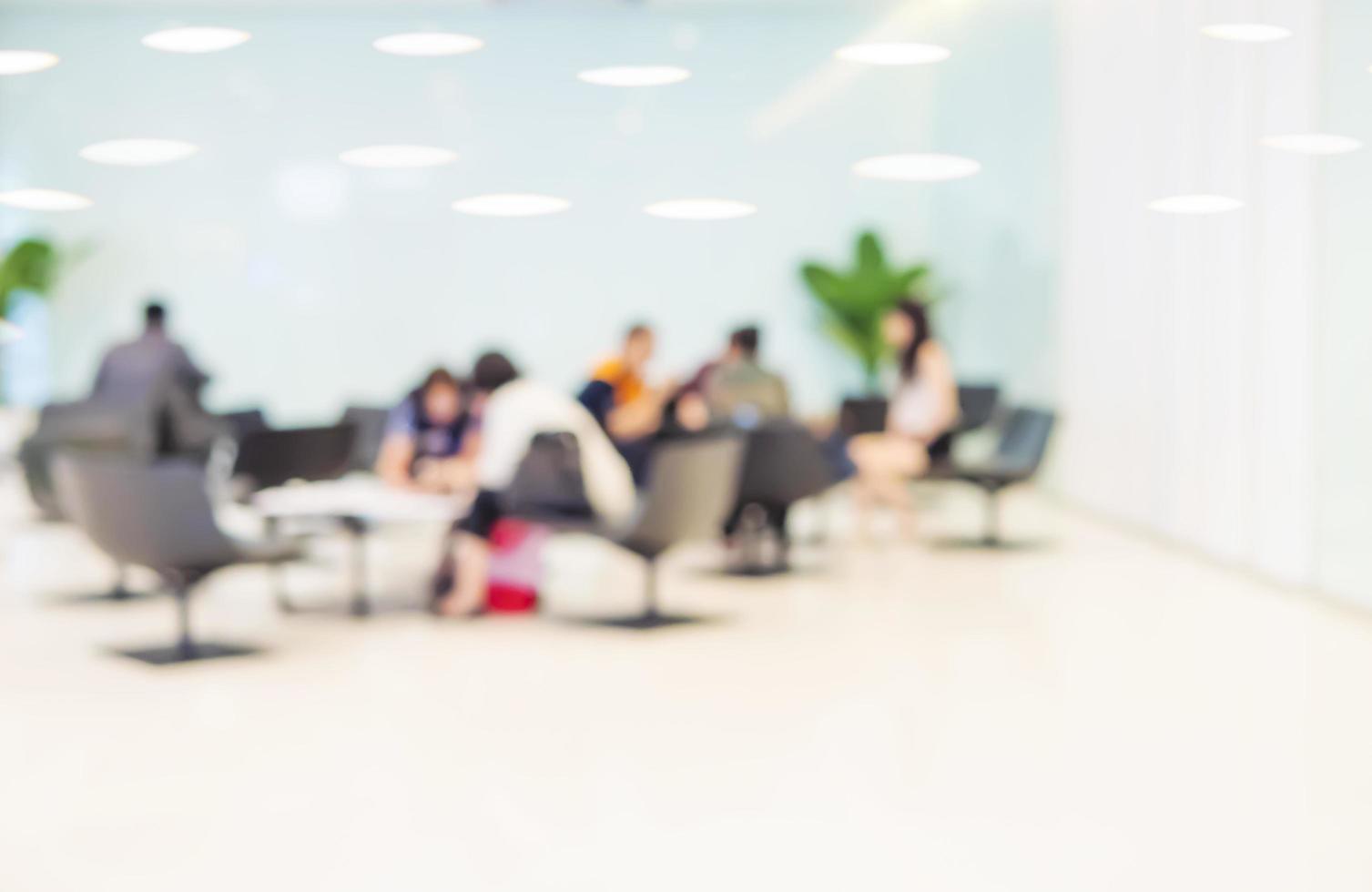 Blurred photo of people in the bright modern office lobby area