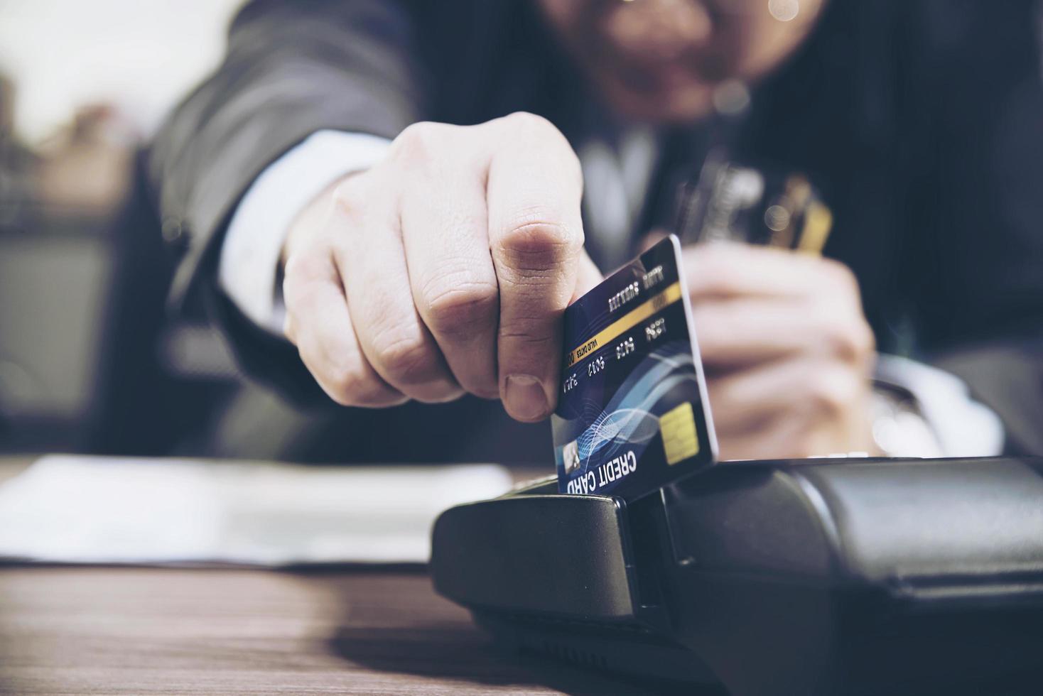 mano del comerciante usando una máquina de tarjetas de crédito foto