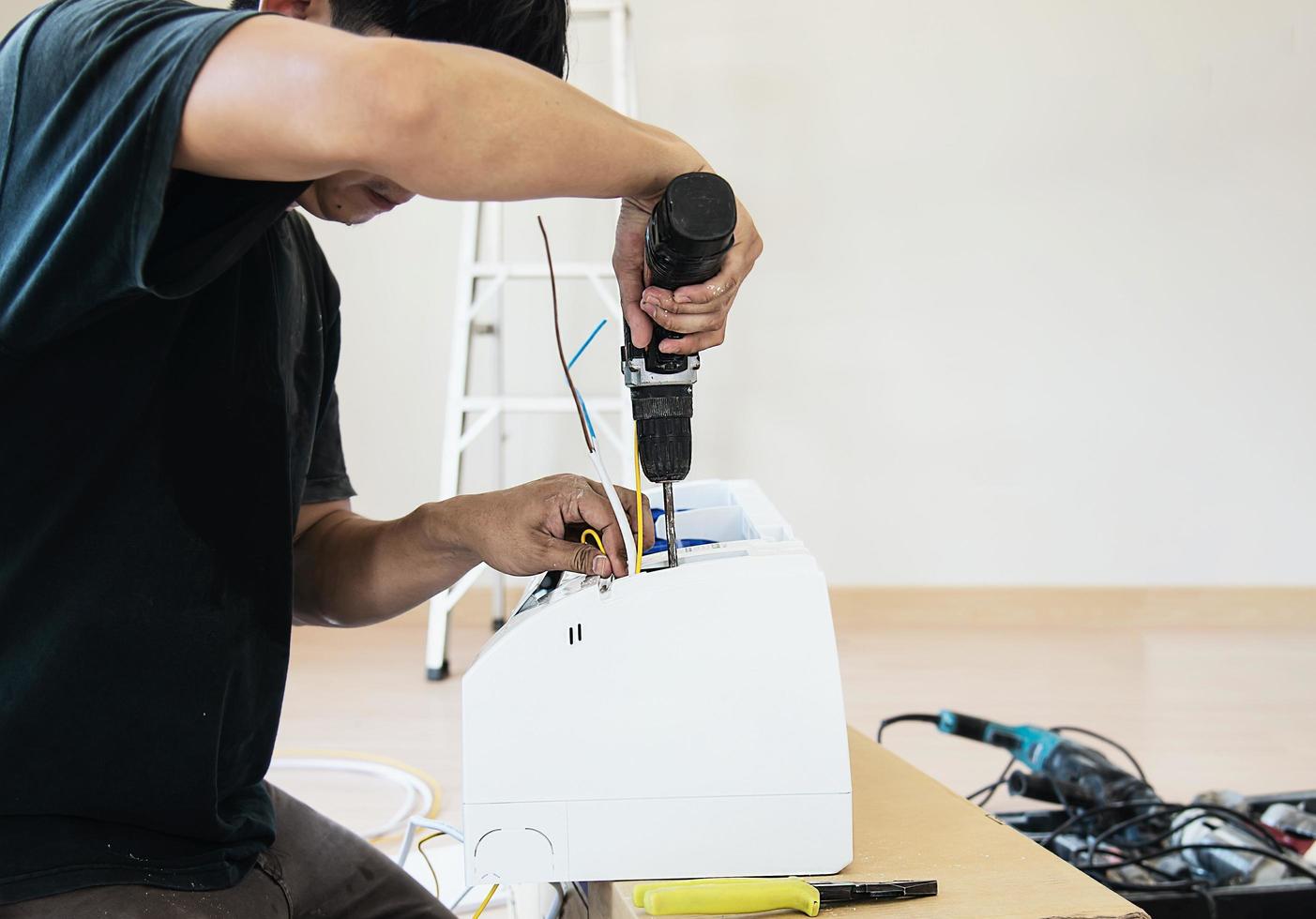 Technician is installing air conditioner during hot season photo