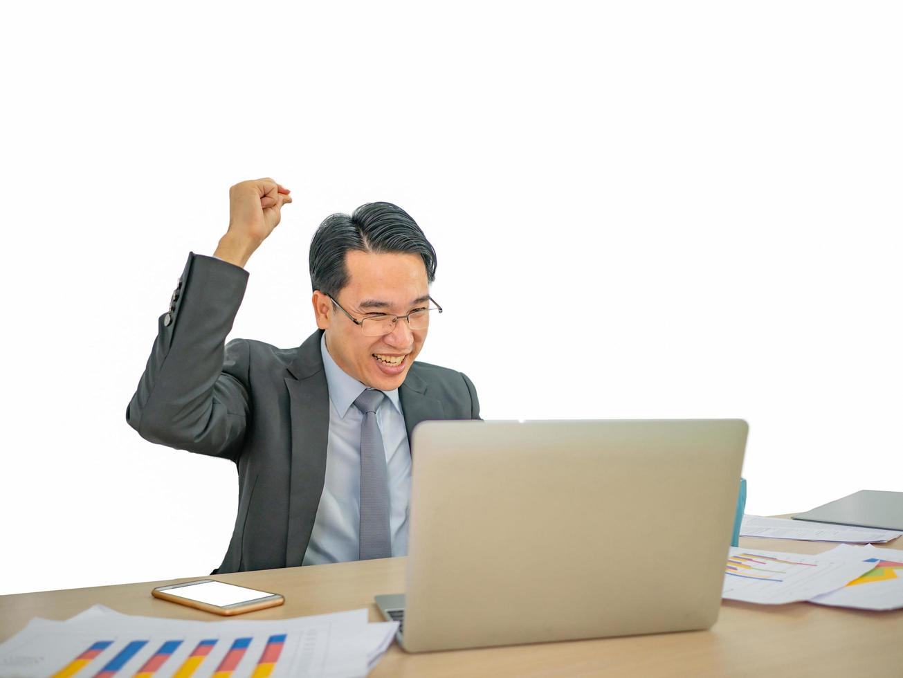 Happy asian business man sitting on his desk on isolated background photo