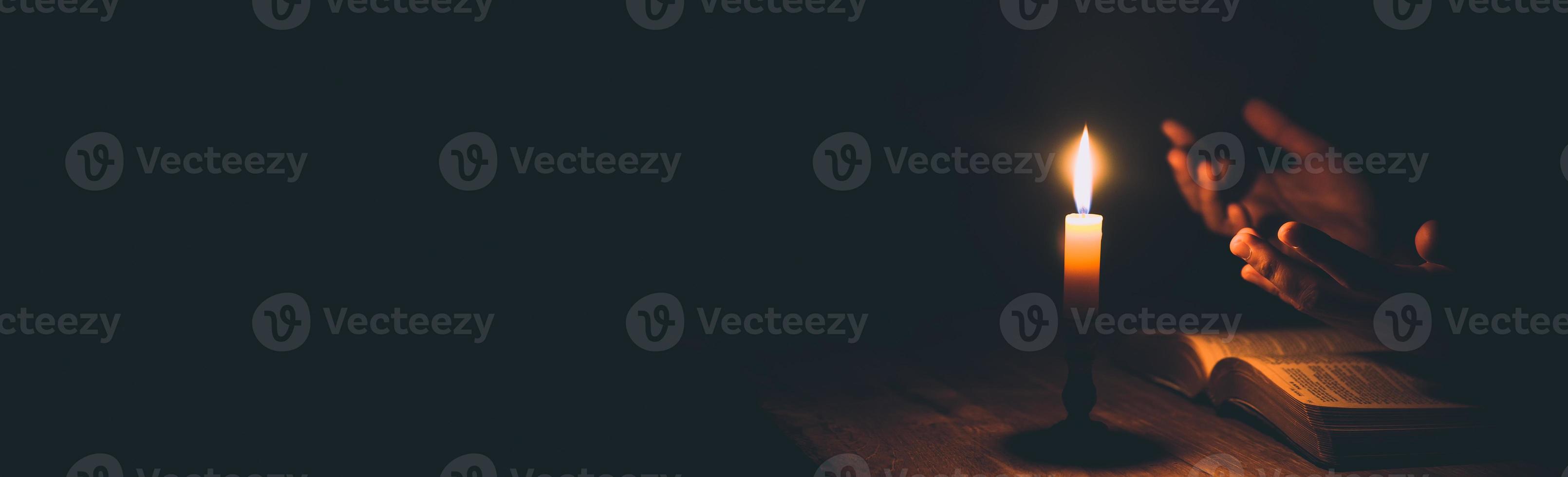 Banner image of Candle with bible on a old oak wooden table photo