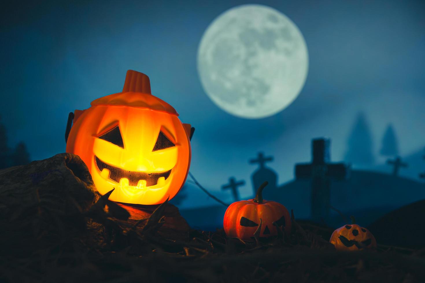 Spooky cemetery with glow halloween pumpkin photo