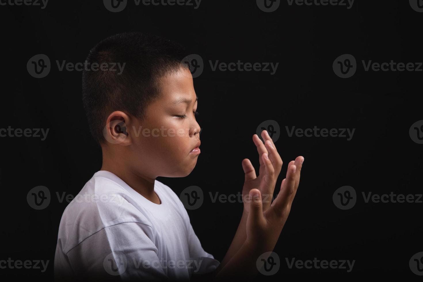 Boy praying to God at home photo