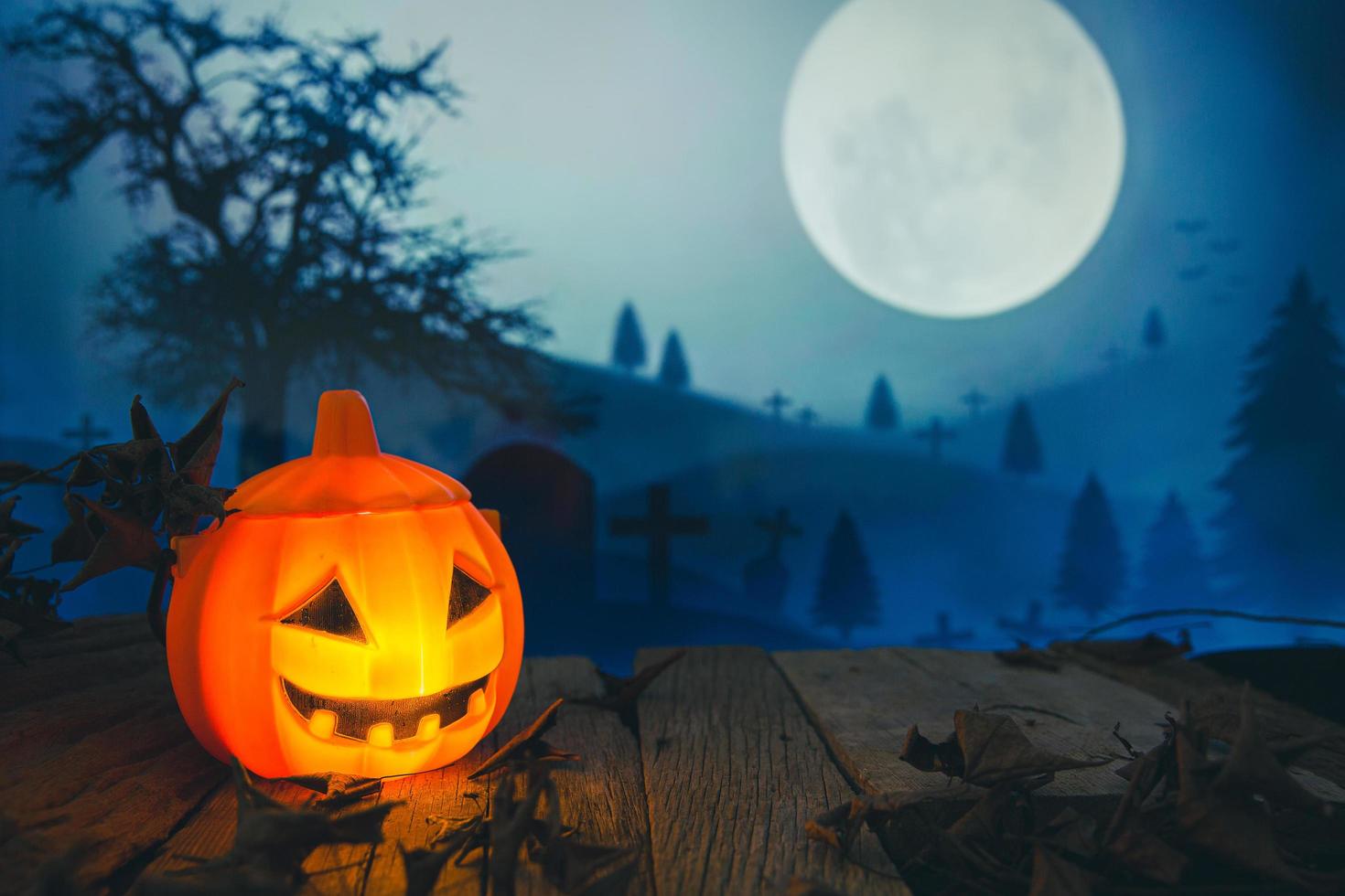 Spooky cemetery with glow halloween pumpkin photo