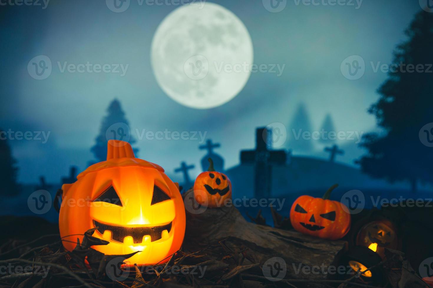 Spooky cemetery with glow halloween pumpkin photo