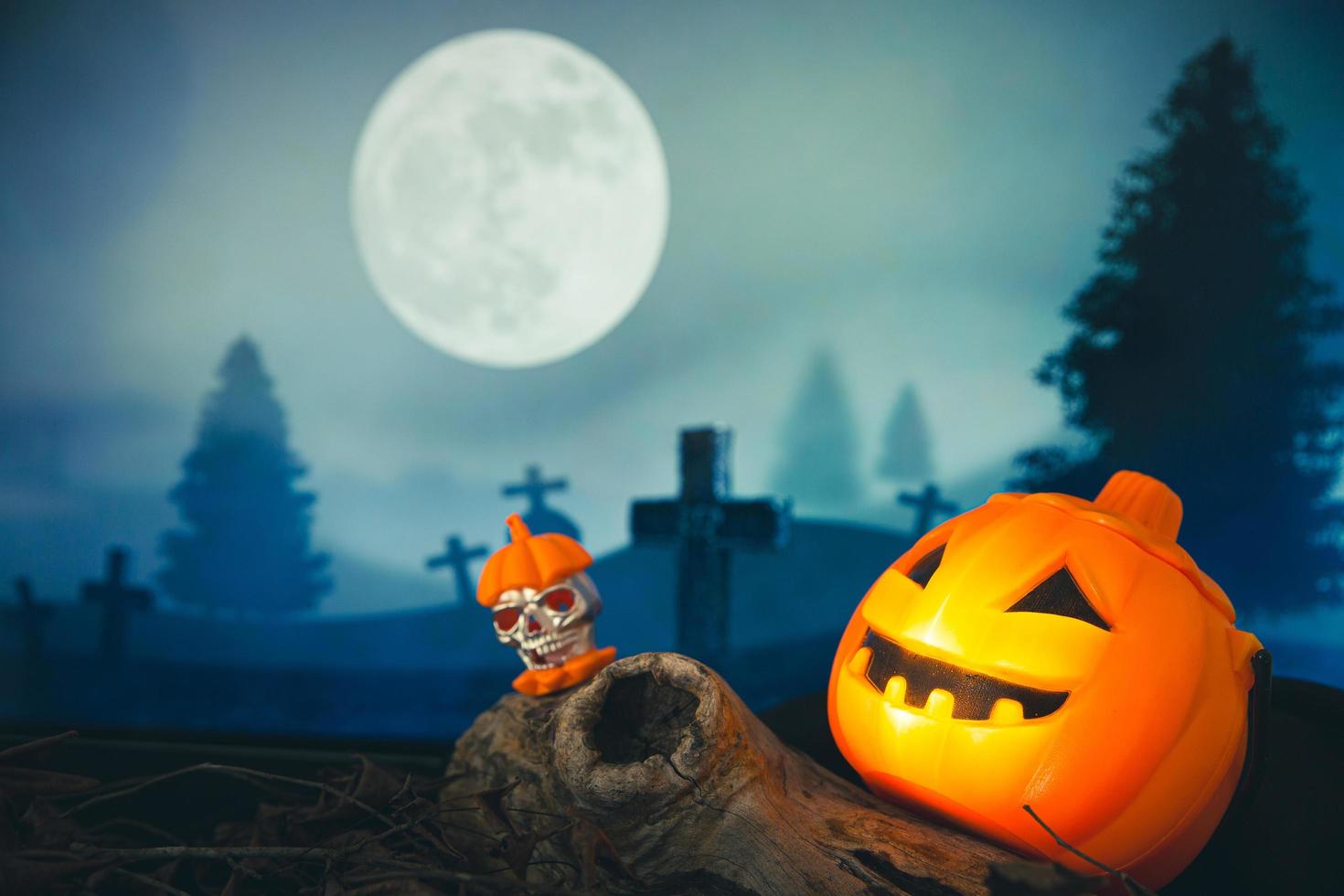 Spooky cemetery with glow halloween pumpkin photo