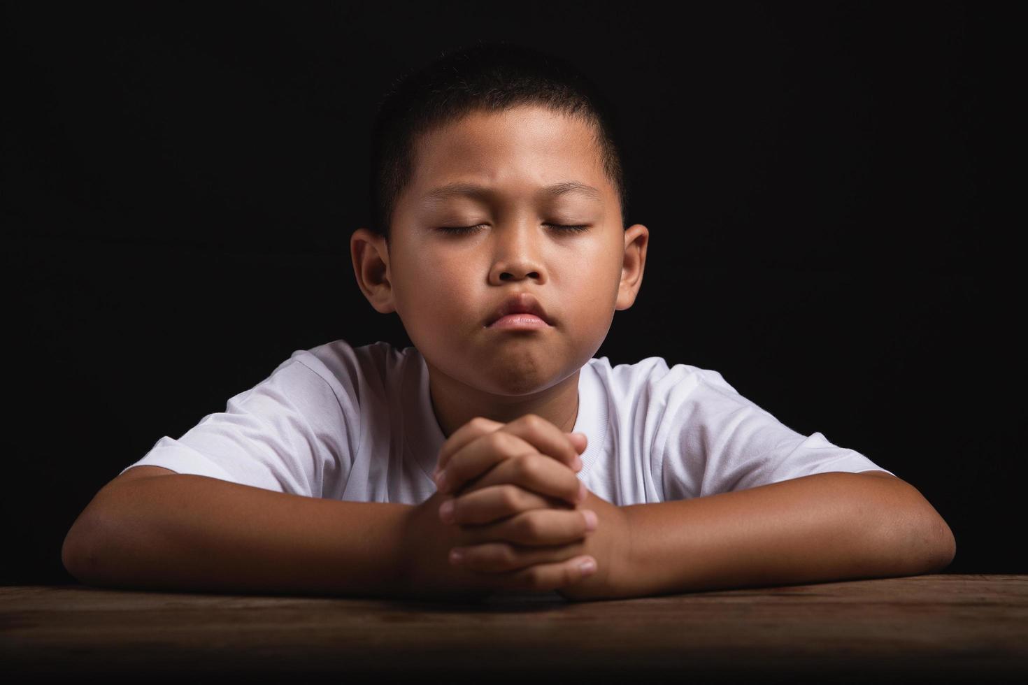 Boy praying to God at home photo