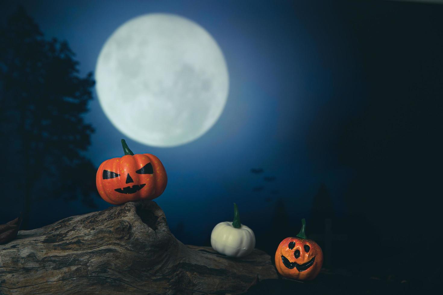 Spooky cemetery with glow halloween pumpkin photo