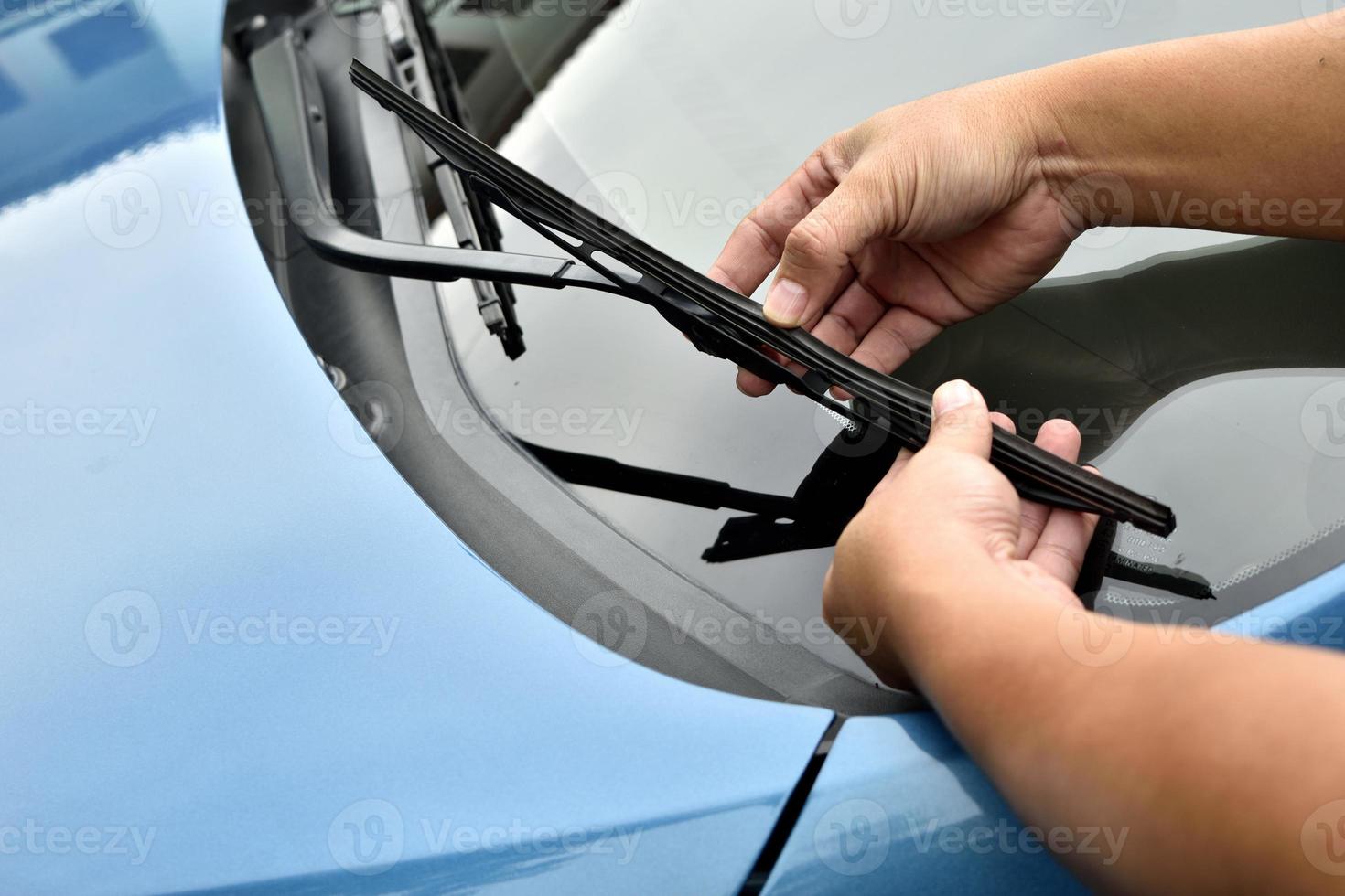 man hand picking up windscreen wiper photo