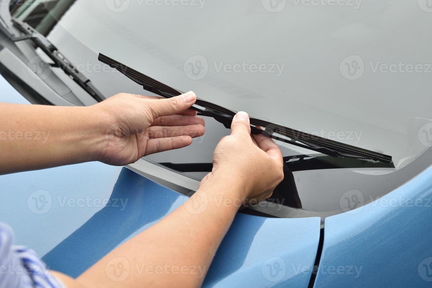 man hand picking up windscreen wiper photo