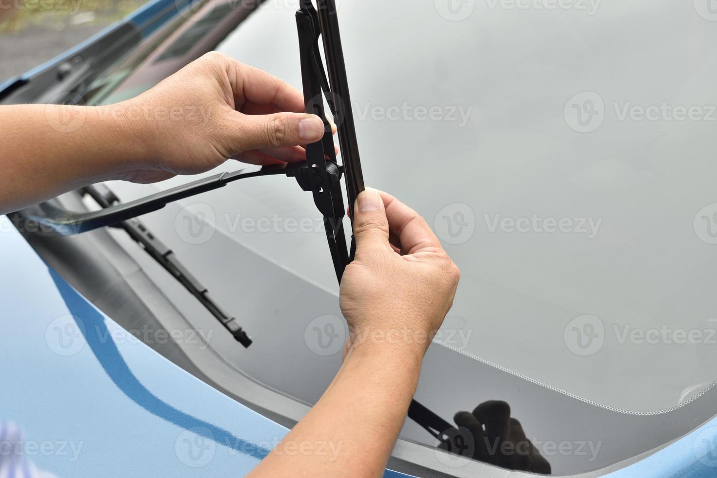 man hand picking up windscreen wiper photo