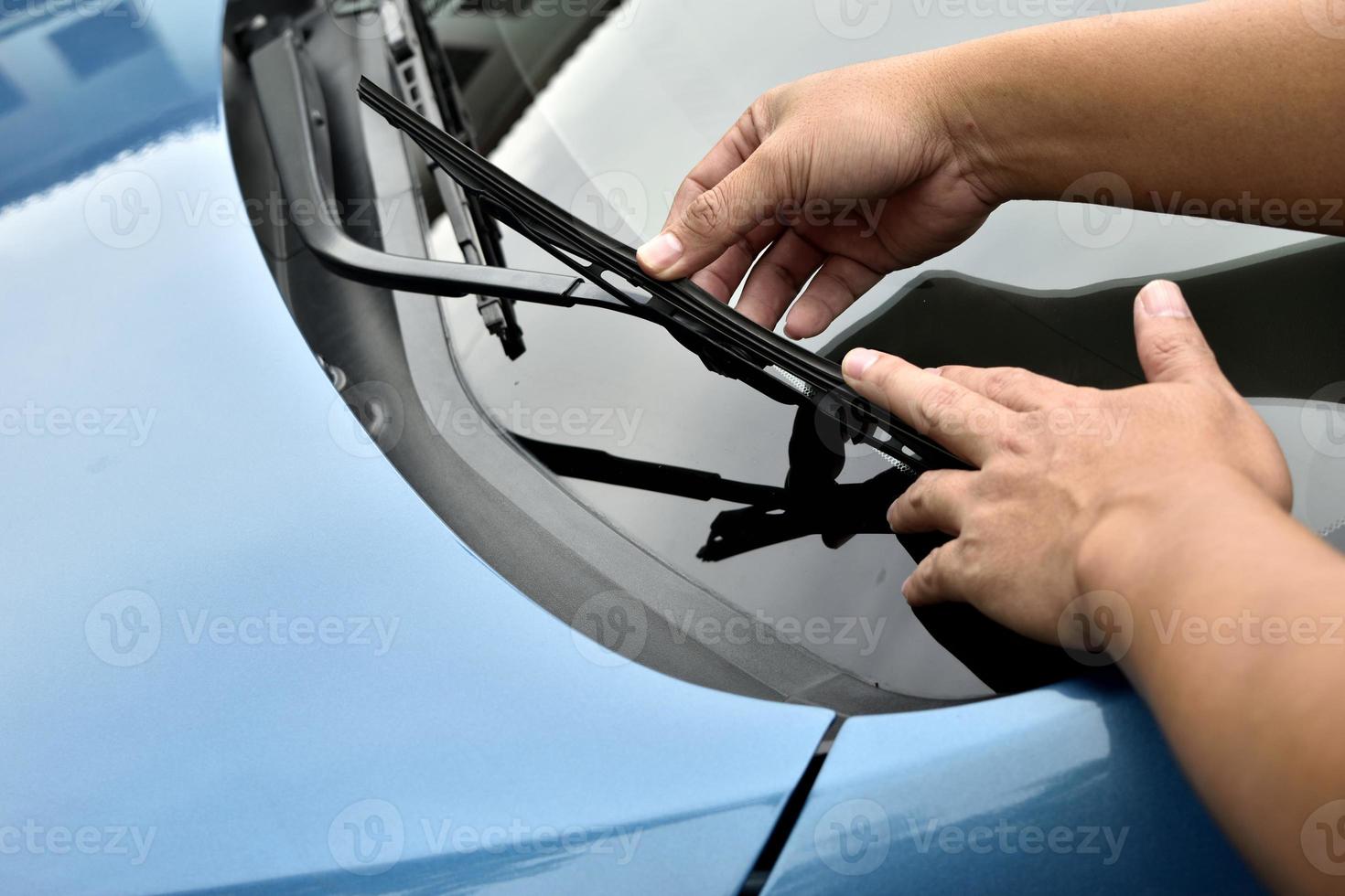 man hand picking up windscreen wiper photo