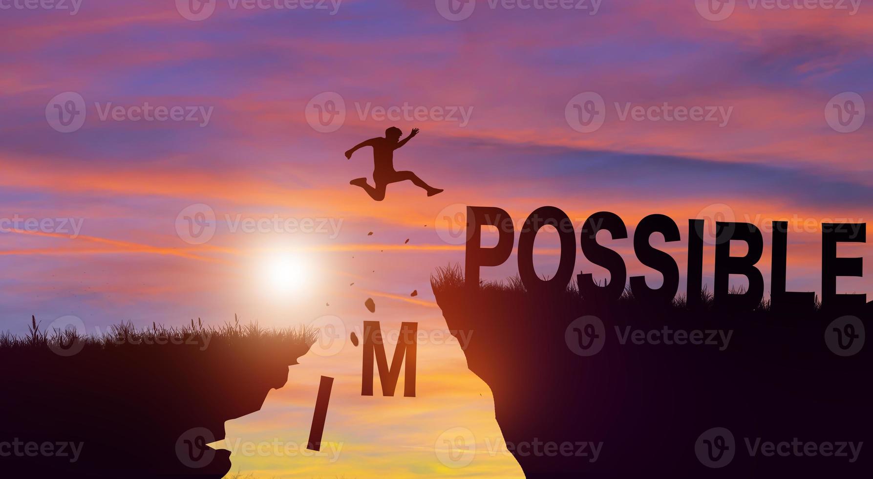 Silhouette man jumping over impossible and possible wording with cloud sky and sunrise. Positive mindset Concept. photo