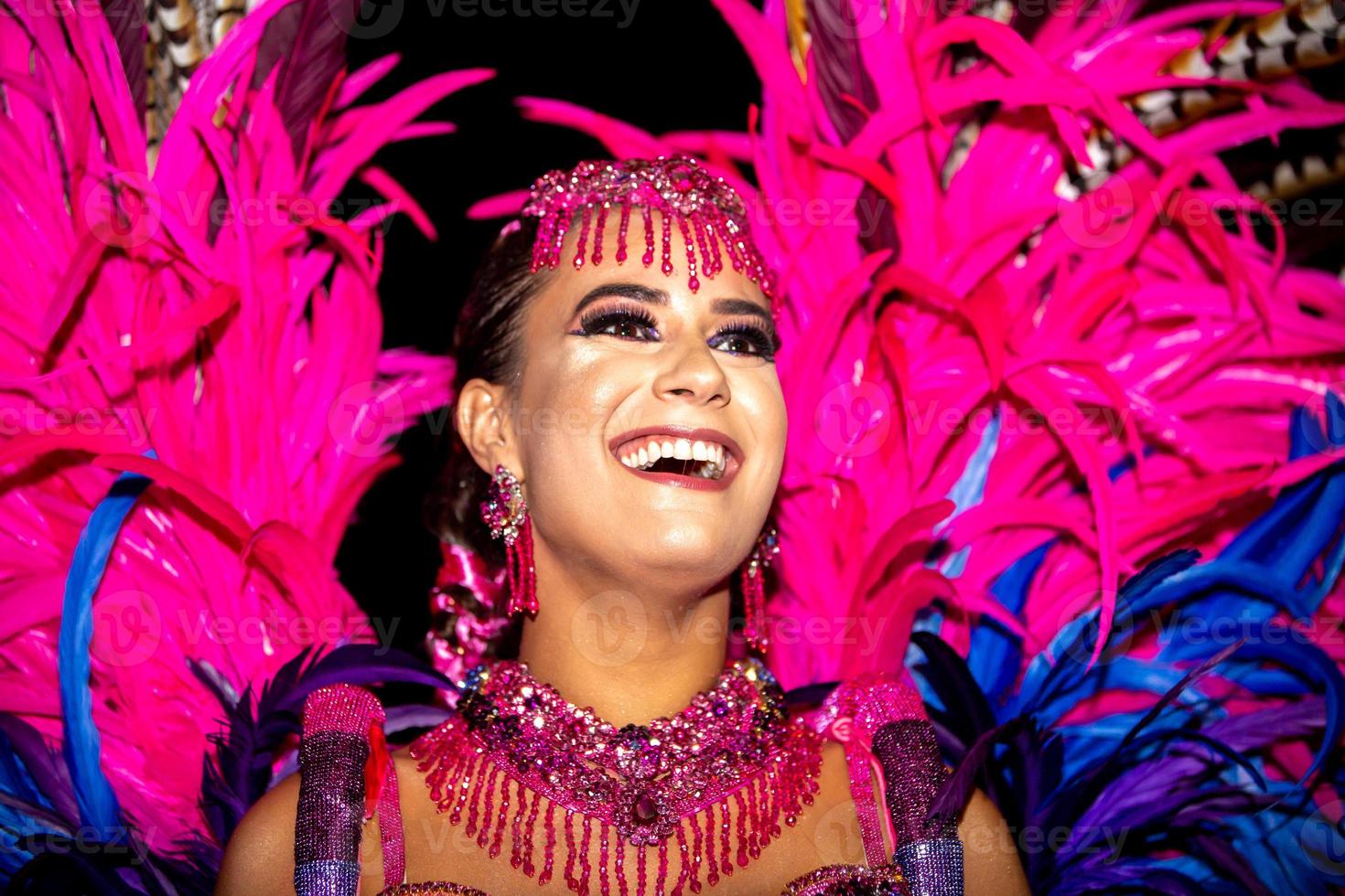 Brazilian wearing Samba Costume. Beautiful Brazilian woman wearing colorful costume and smiling during Carnaval street parade in Brazil. photo