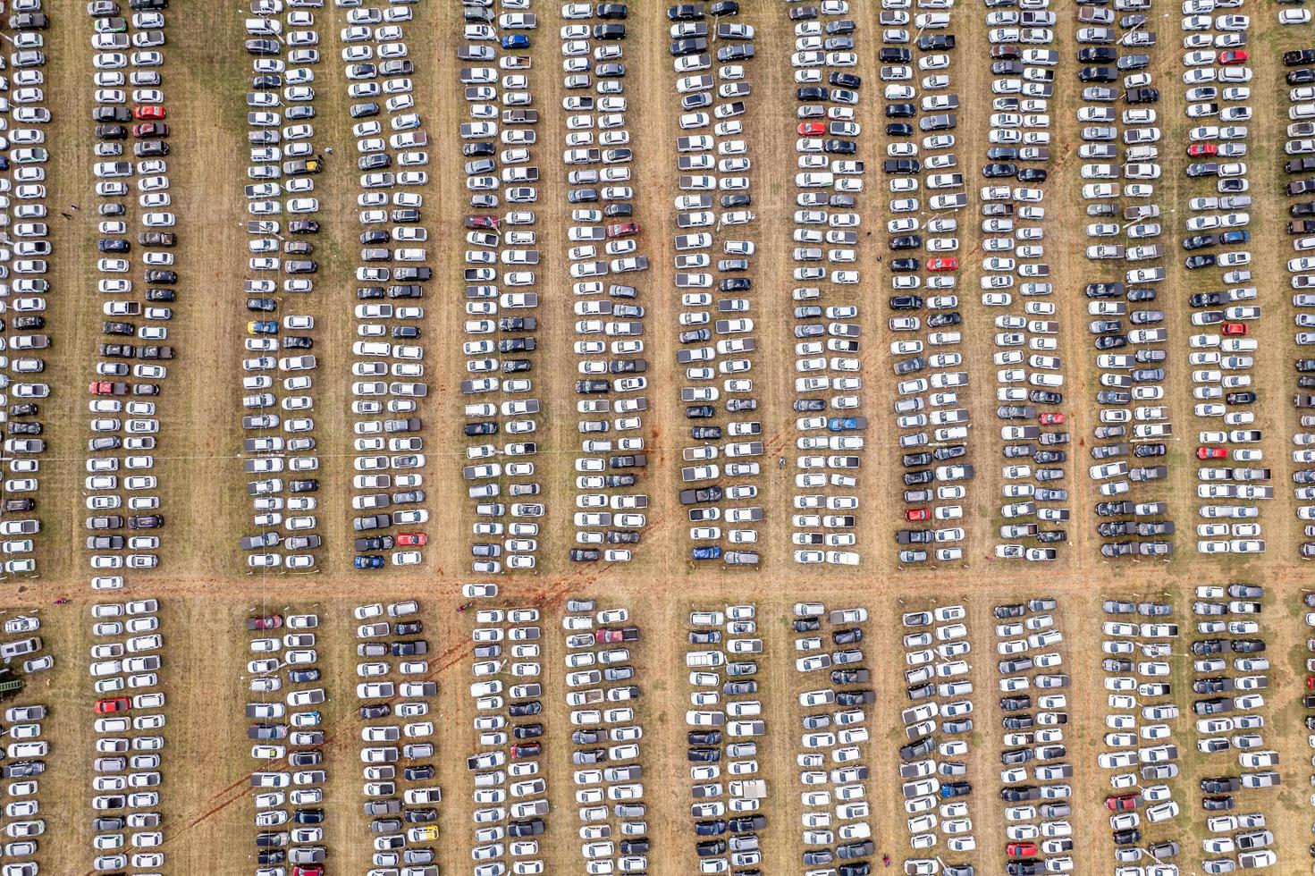 vista aérea de un centro de distribución de automóviles, automóviles estacionados en filas en un lote listo para la venta. coches alineados en el puerto para la importación y exportación. foto