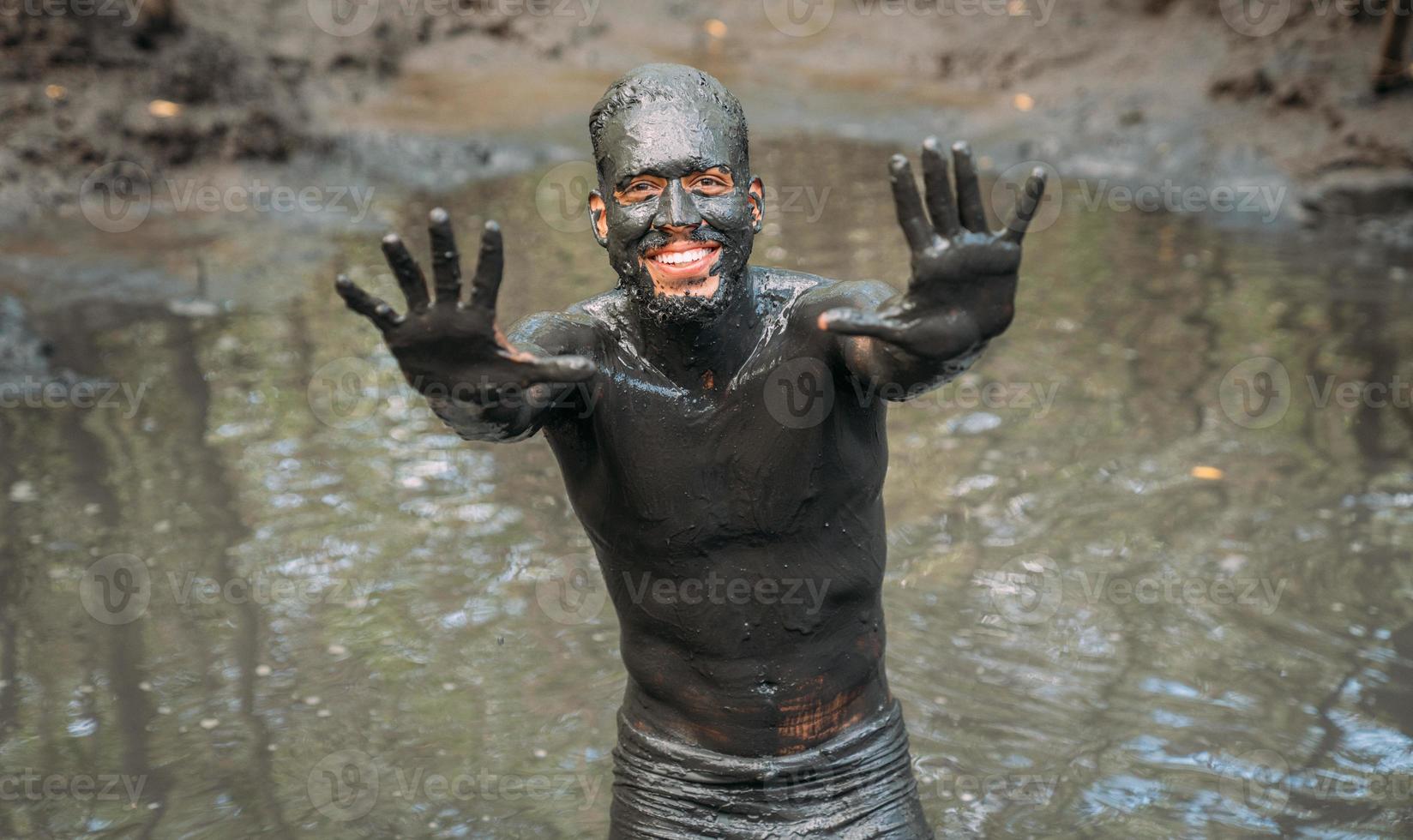 smiling young latin american man getting green clay treatment photo