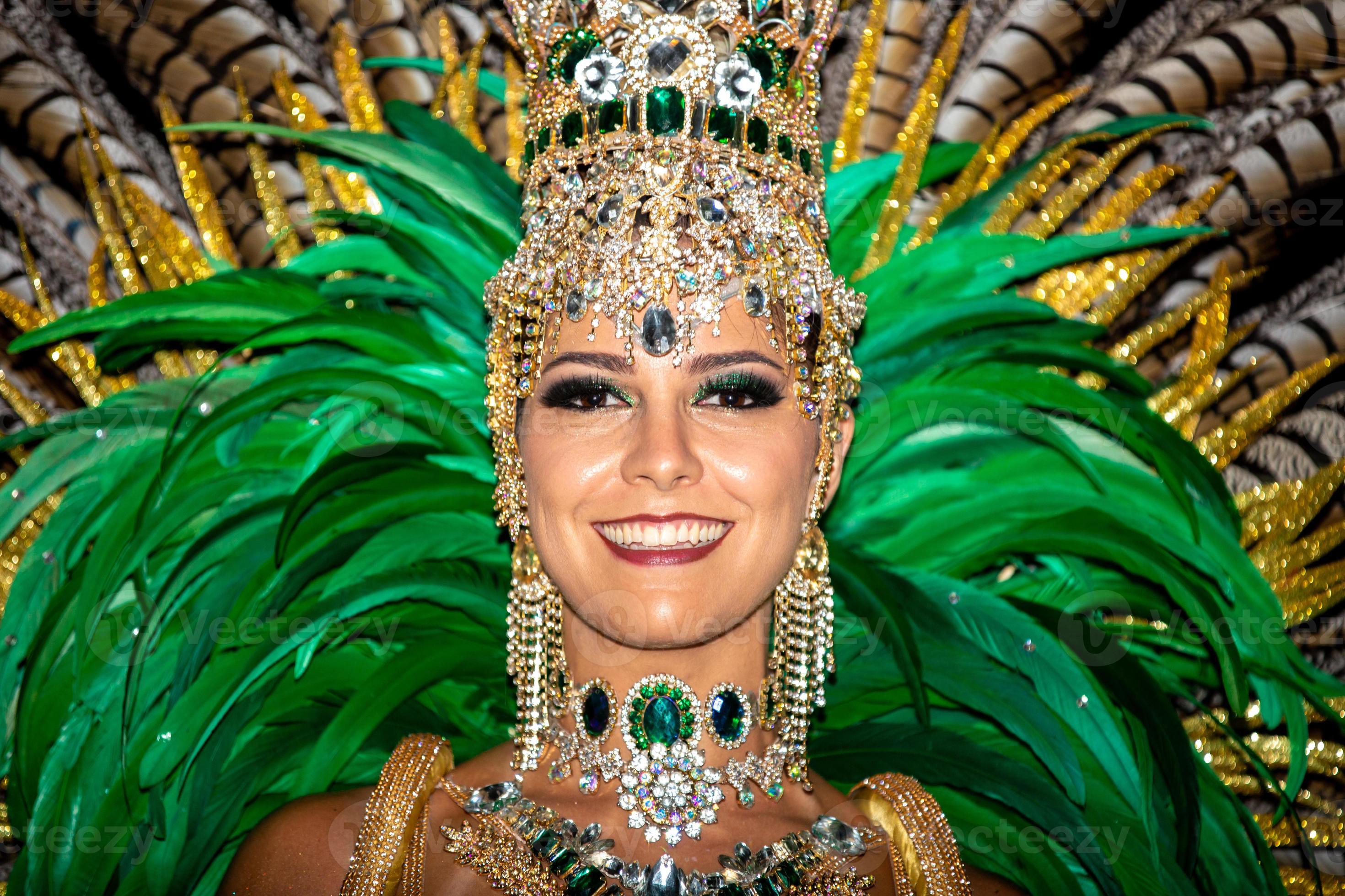 Hermosa mujer brasileña vistiendo coloridos trajes de carnaval y sonriendo  durante el desfile de carnaval en la ciudad.