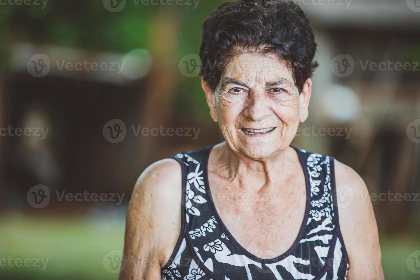 retrato de una hermosa granjera mayor sonriente. mujer en la granja en día de verano. actividad de jardinería. anciana brasileña. foto