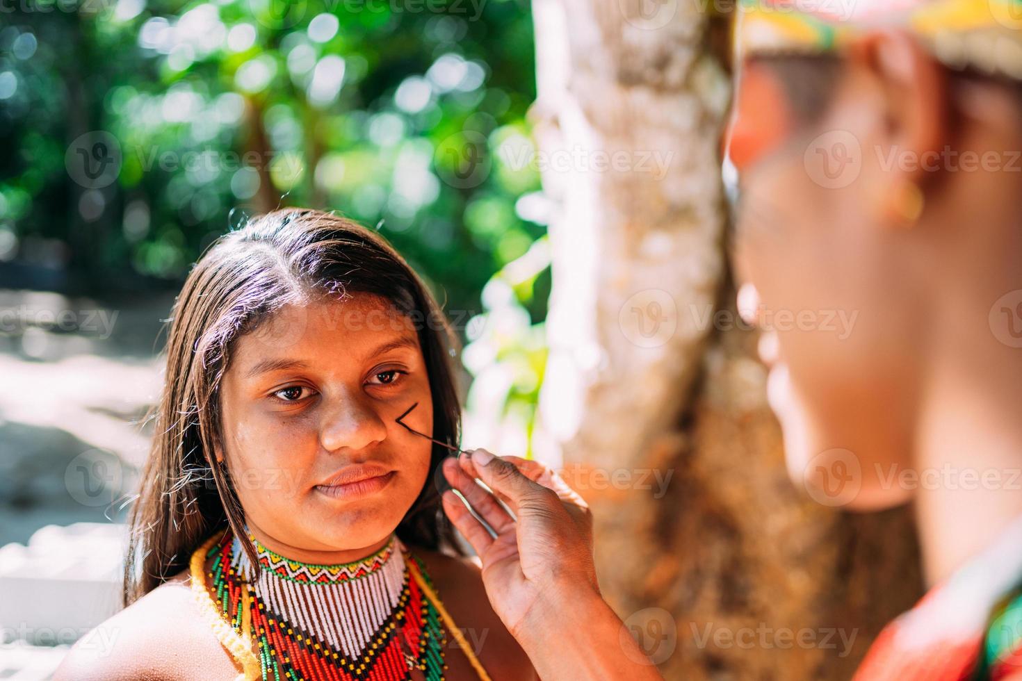 Portrait of young girl indigenous Pataxo ethnicity doing face painting photo