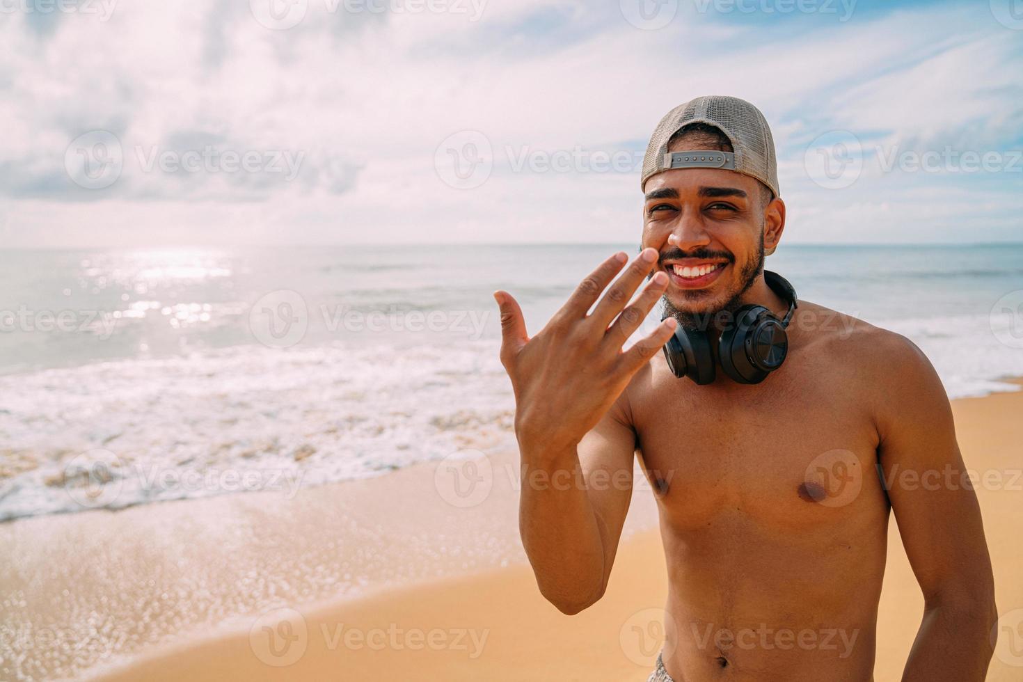 Friendly young Latin American man inviting to come to Brazil, confident and smiling making a gesture with his hand, being positive and friendly photo