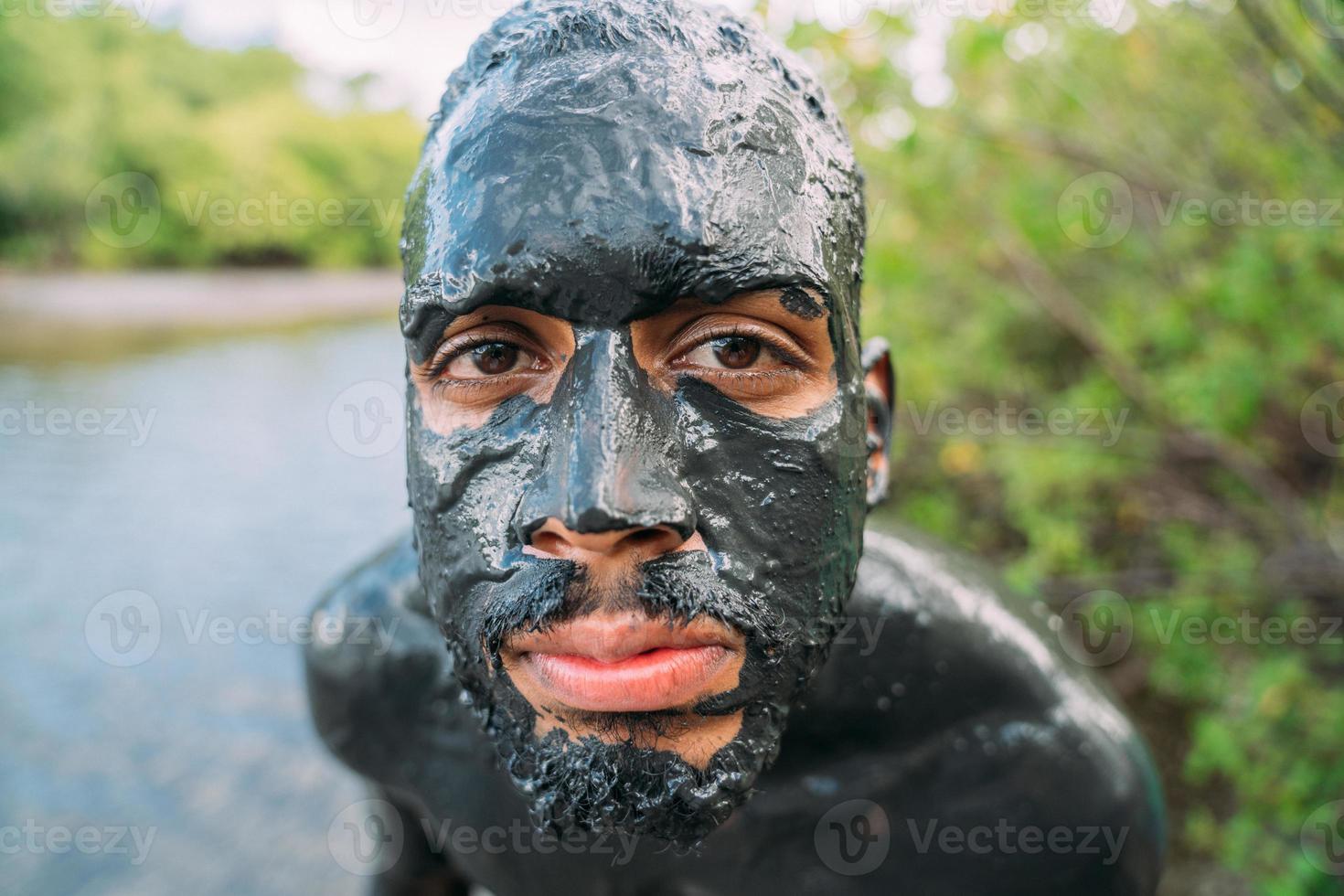 young latin american man getting green clay treatment photo