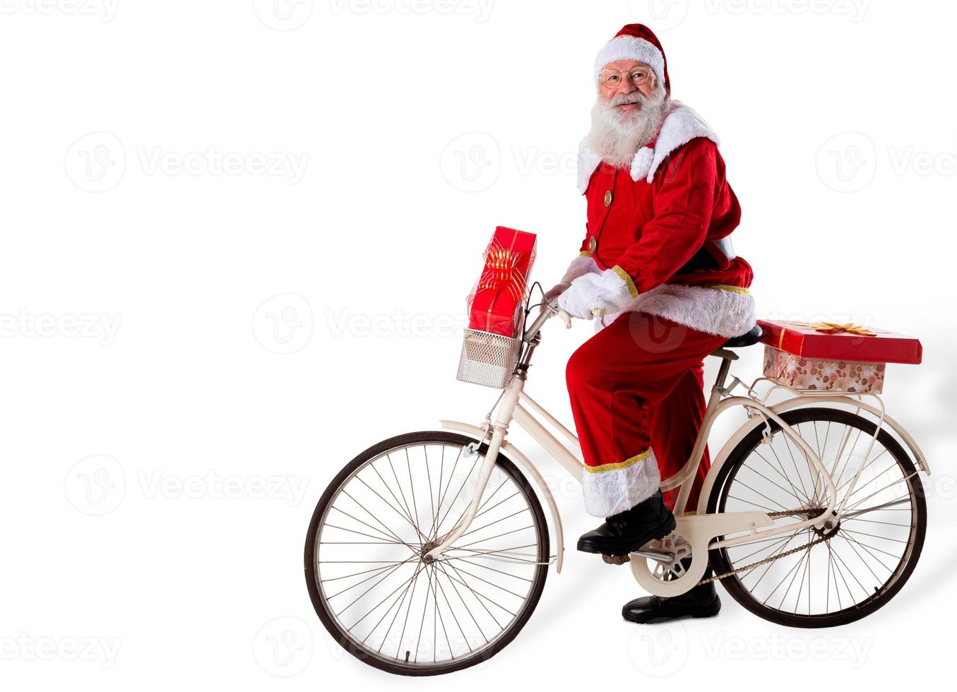 Santa Claus on bicycle delivering Christmas gifts. photo