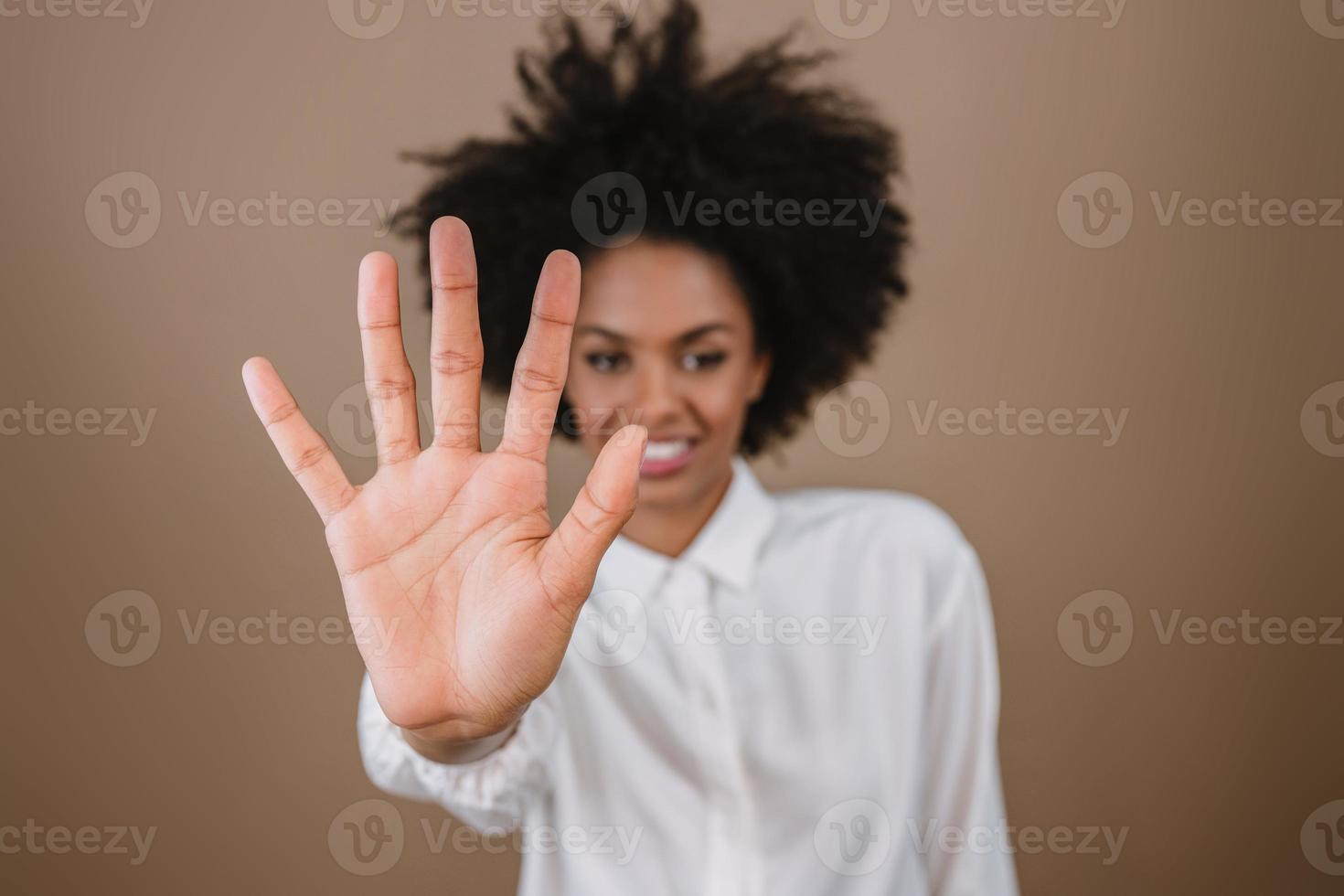 mujer latina sonriente haciendo cinco tiempos de cuenta regresiva gesto de signo con los dedos de la mano sobre fondo pastel. foto