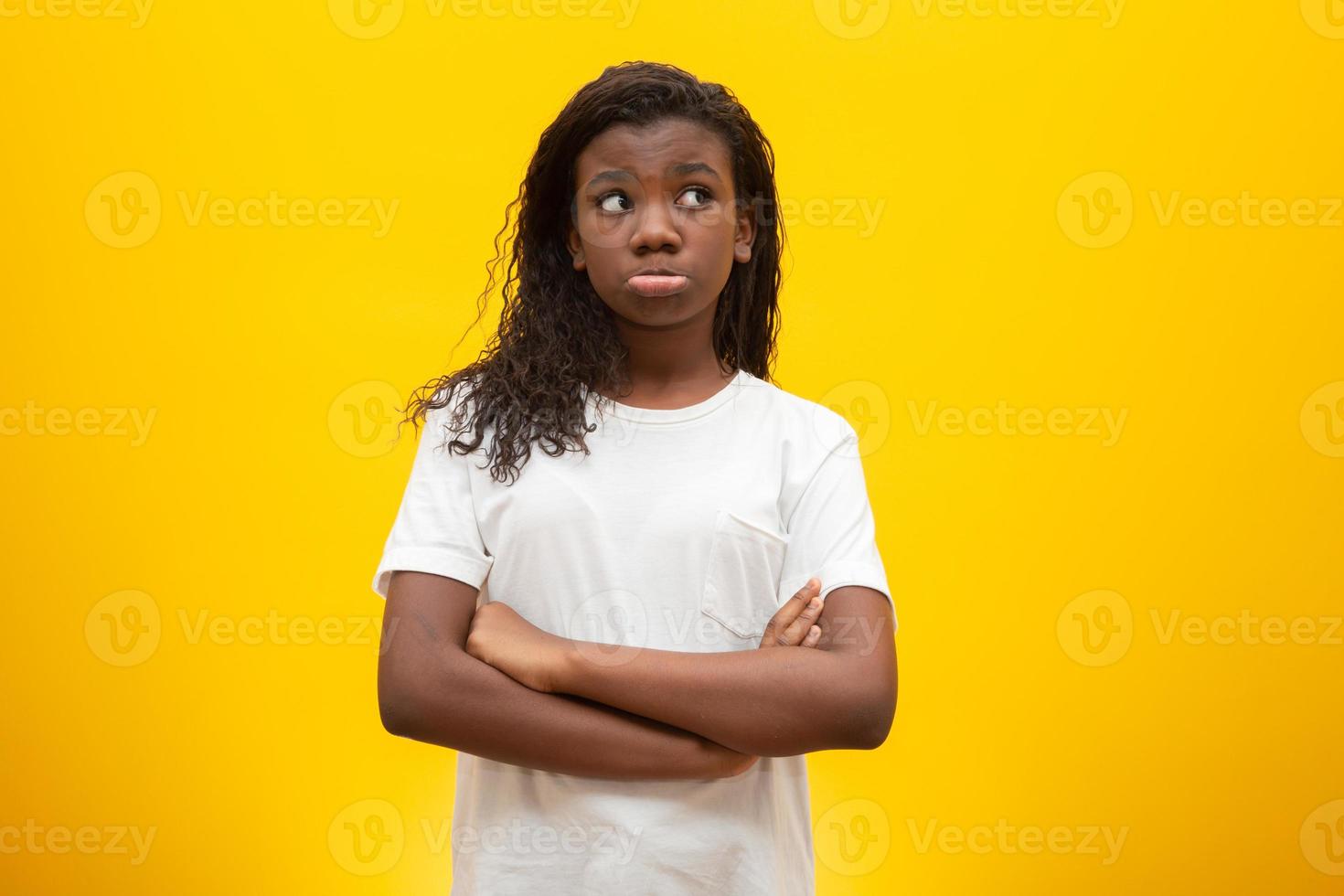 Thoughtful children on yellow background. photo