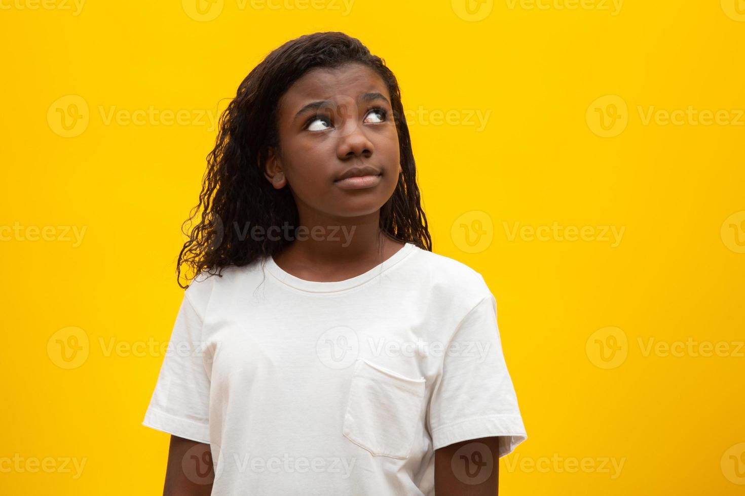 Thoughtful children on yellow background. photo