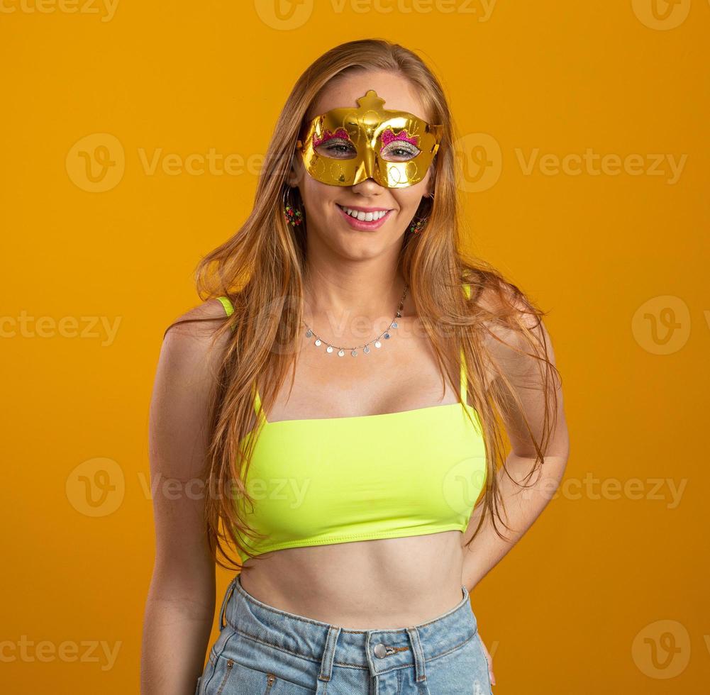 Beautiful woman dressed for carnival night. Smiling woman ready to enjoy the carnival with a colorful mask. photo