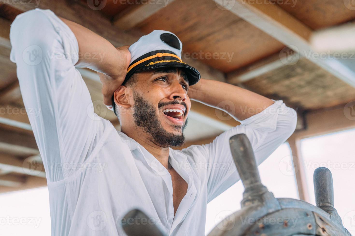 deporte de vela capitán a cargo. hombre latinoamericano con sombrero de capitán de barco preocupado por los piratas foto