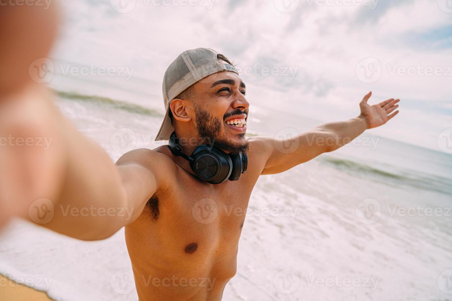 Friendly young Latin American man inviting to come to Brazil, confident and smiling making a gesture with his hand, being positive and friendly photo