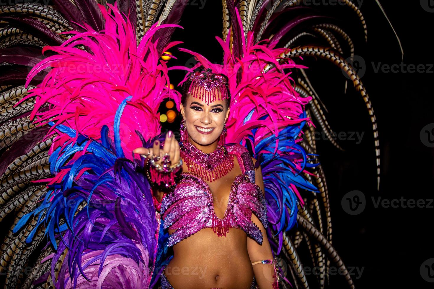 brasileño con traje de samba. hermosa mujer brasileña con traje colorido y sonriendo durante el desfile callejero de carnaval en brasil. foto