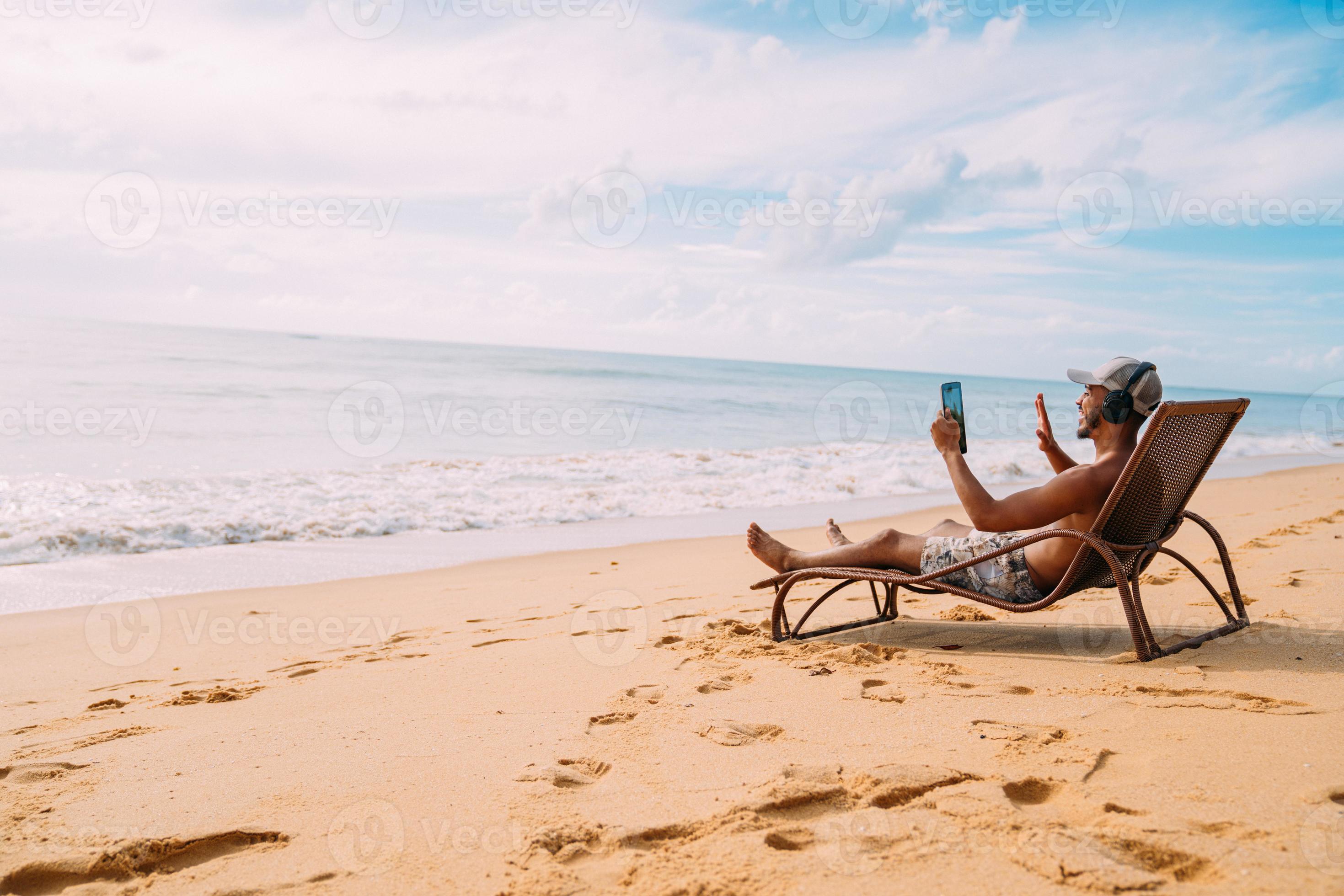 Man making a video call on summer vacation. latin american man sitting
