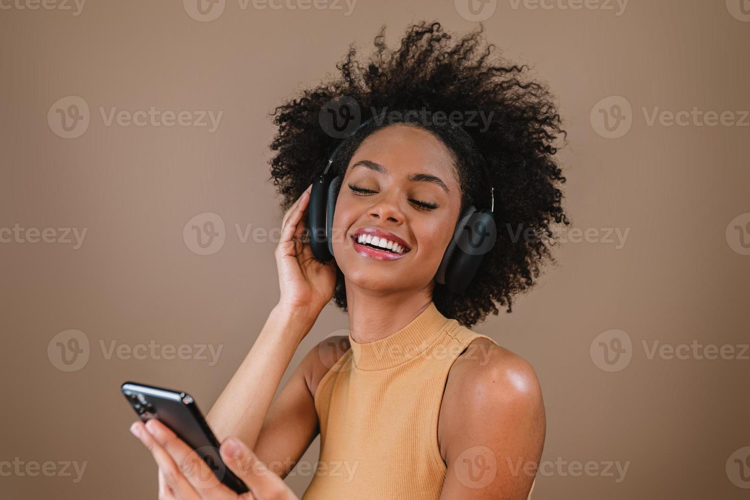 hermosa chica latina usando su teléfono móvil. escuchando música en los auriculares. foto