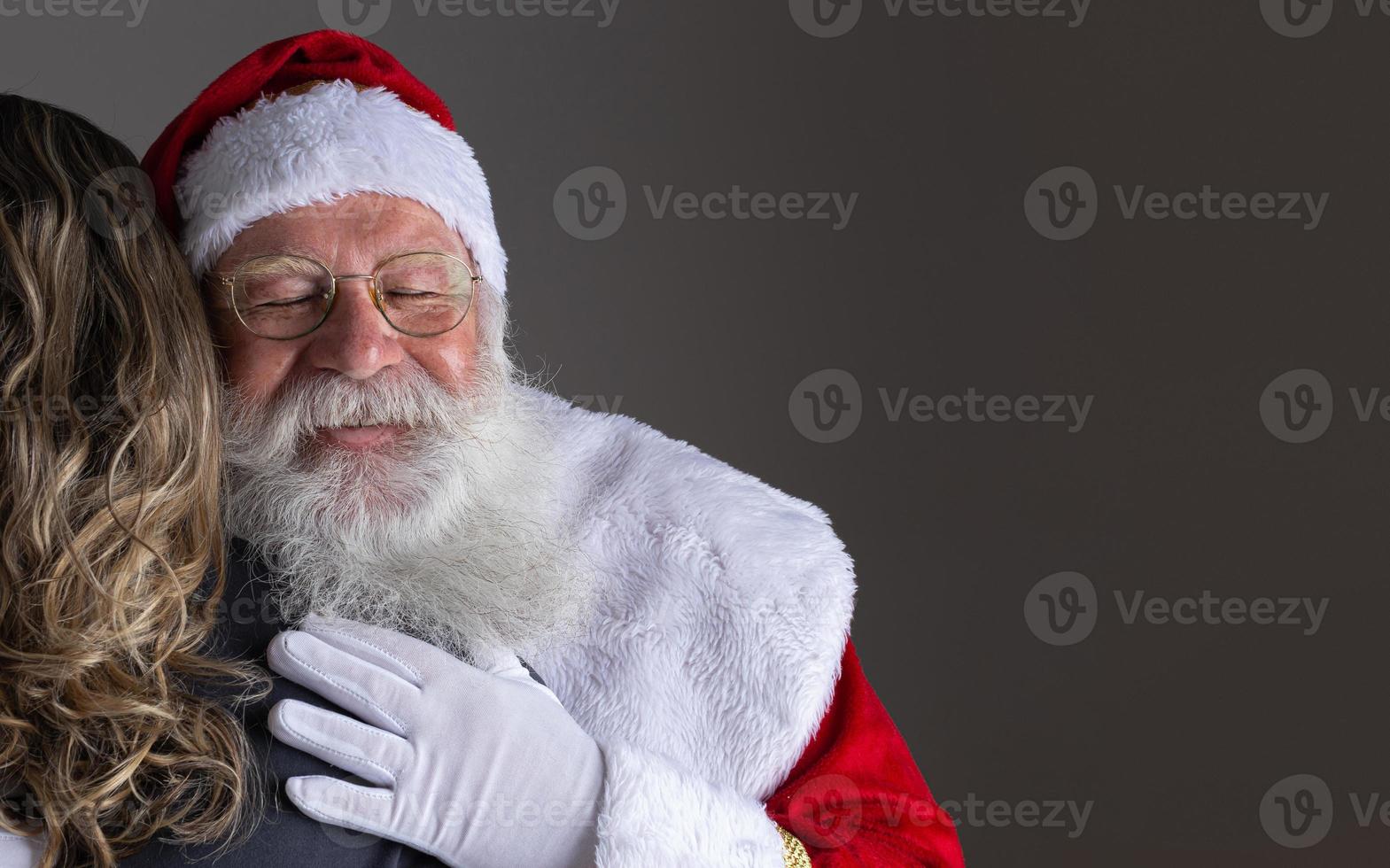 Happy Santa Claus hugging woman, gratitude and love on Christmas night. photo