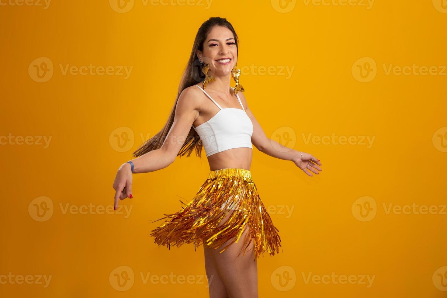 hermosa mujer vestida para la noche de carnaval. mujer sonriente lista para disfrutar del carnaval con un maquillaje colorido. en amarillo foto