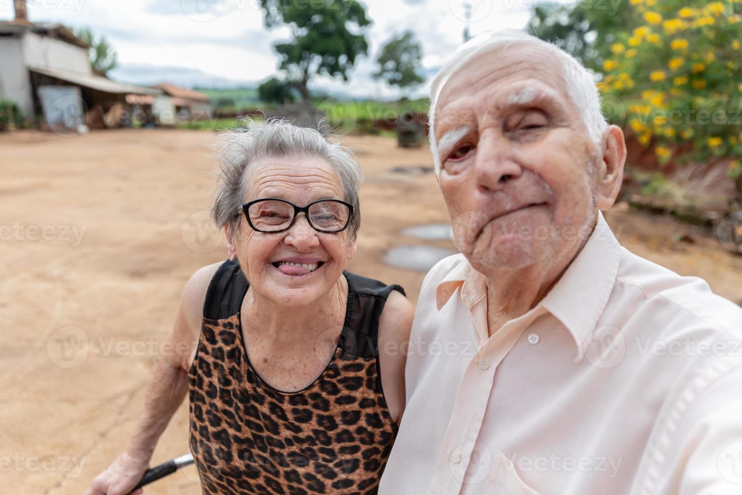 Couple of elderly farmers taking picture with smartphone. photo