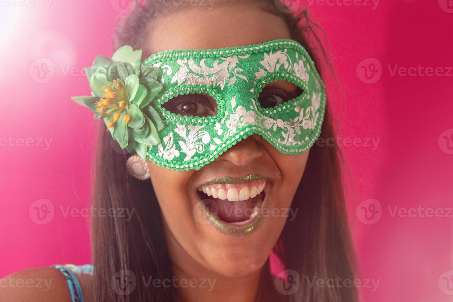 happy young woman with mask and confetti at carnaval party. Brazilian Carnival photo