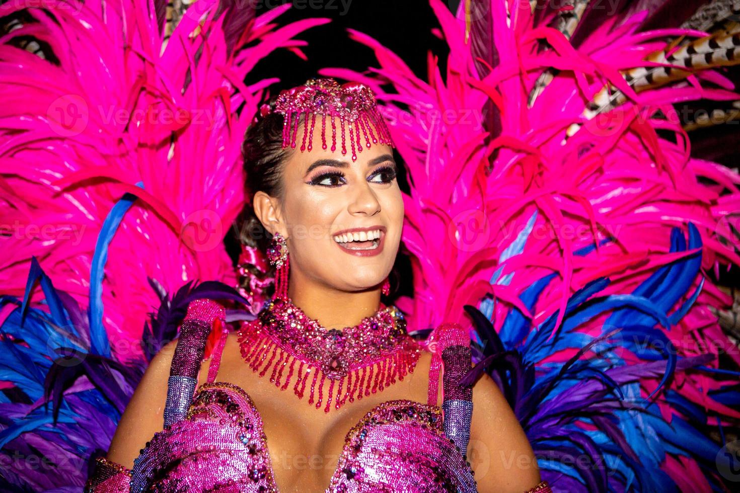 Hermosa mujer brasileña vestida con colorido disfraz de carnaval y bandera  de brasil durante el carnaval en la calle p