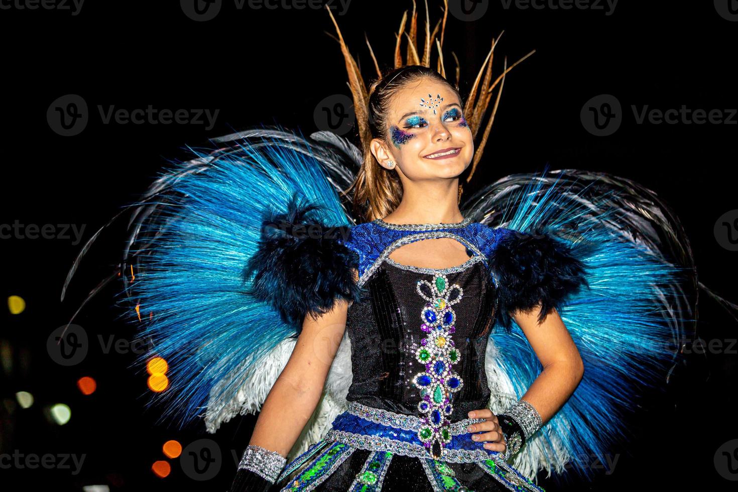 Brazilian teen wearing Samba Costume. Beautiful Brazilian kid woman wearing colorful costume and smiling during Carnaval street parade in Brazil. photo