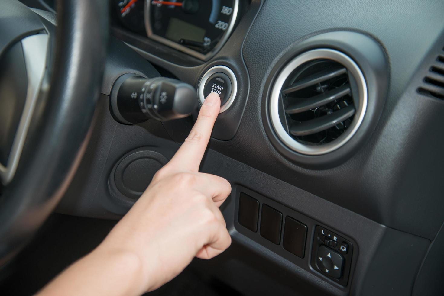 Business woman push an engine start button photo