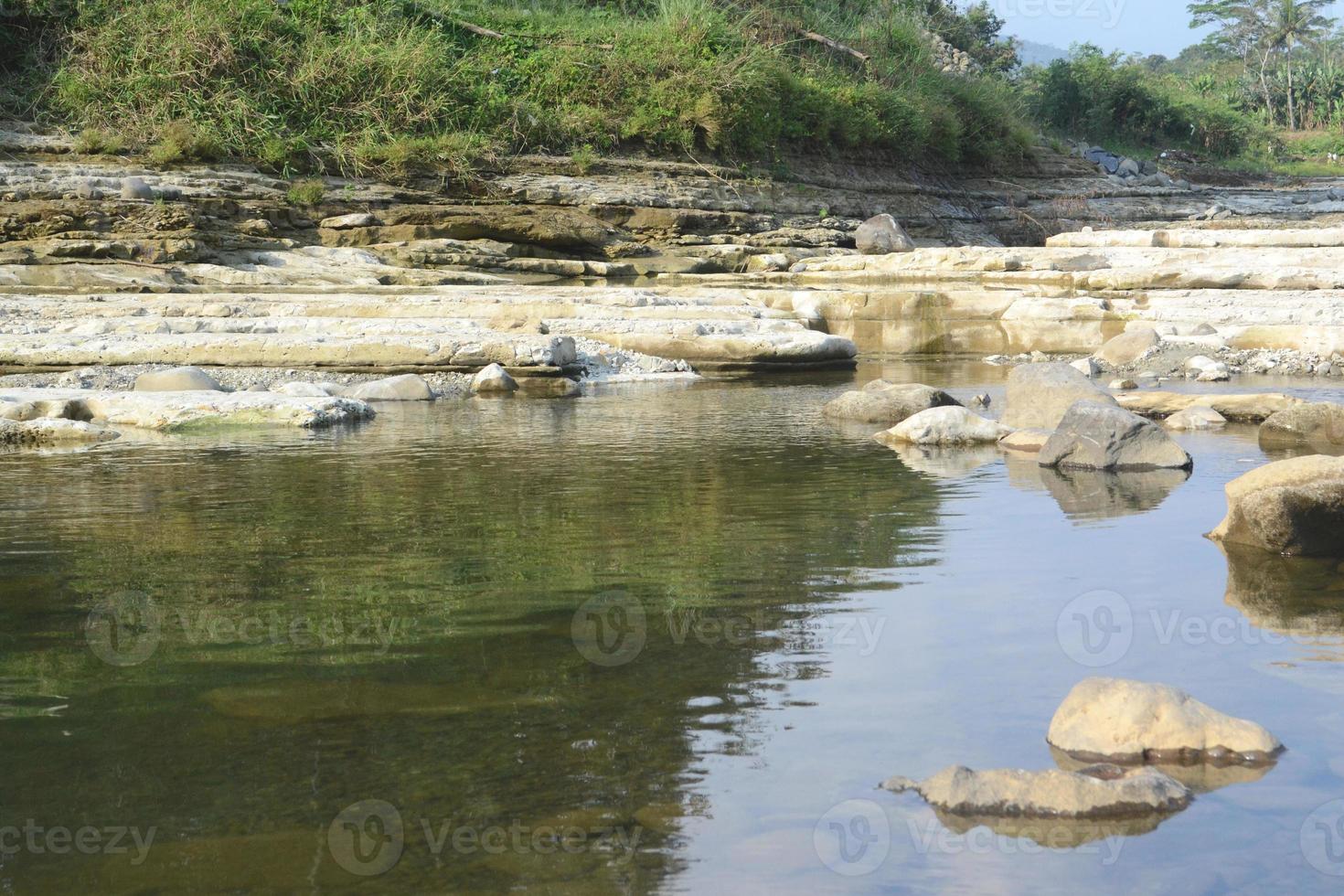 Rocks on the Riverside with Reflection in The Water photo
