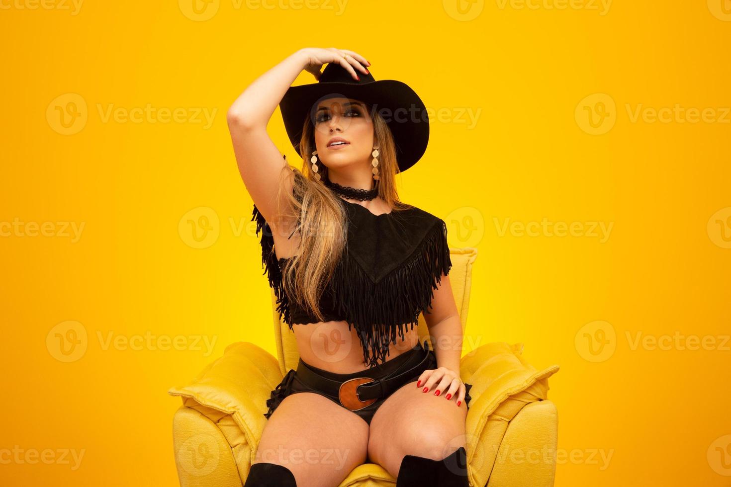 Happy sexy cowgirl on yellow background photo