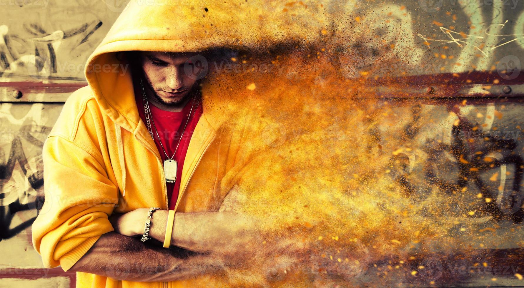 Young man in hooded sweatshirt on grunge wall photo