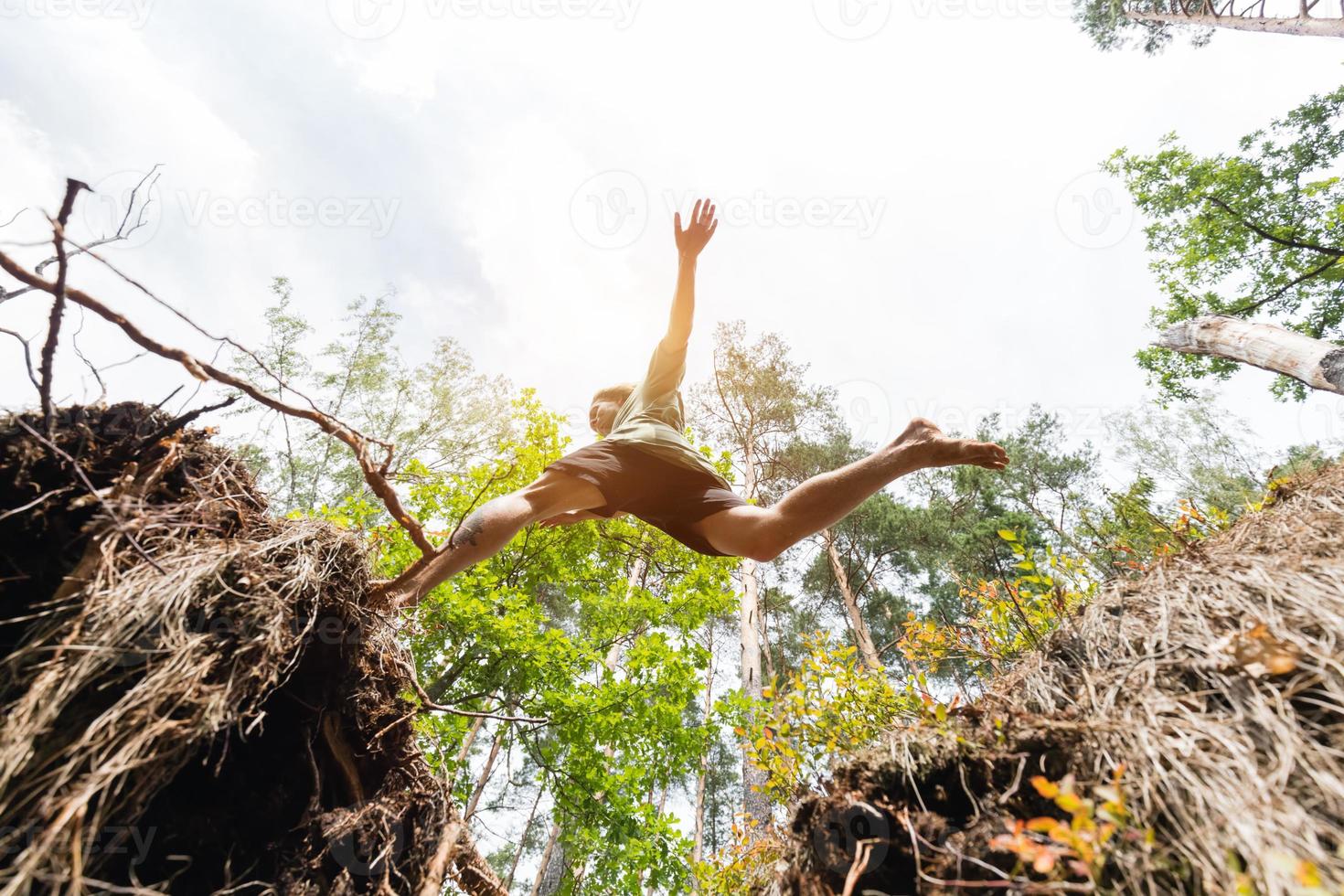 Young man making a jump in the forest. photo