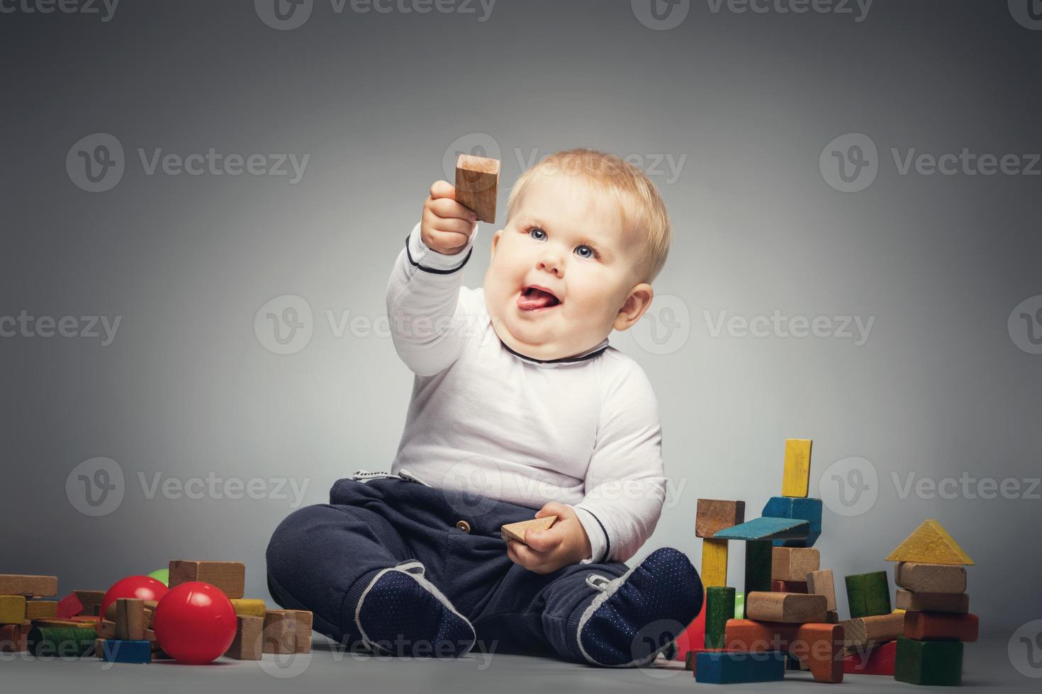 Little boy handing a wooden brick. photo