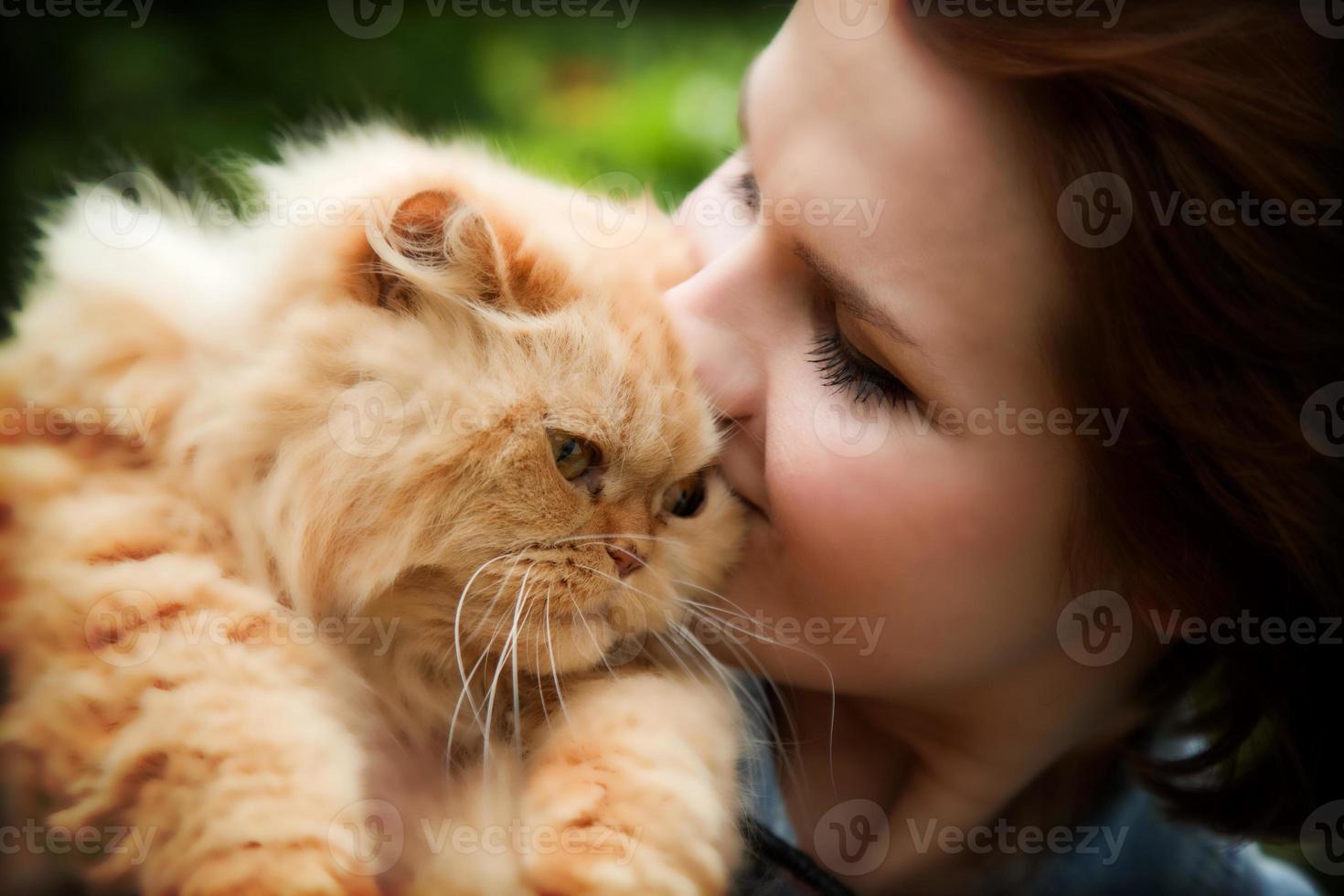 Young woman with Persian cat playing photo