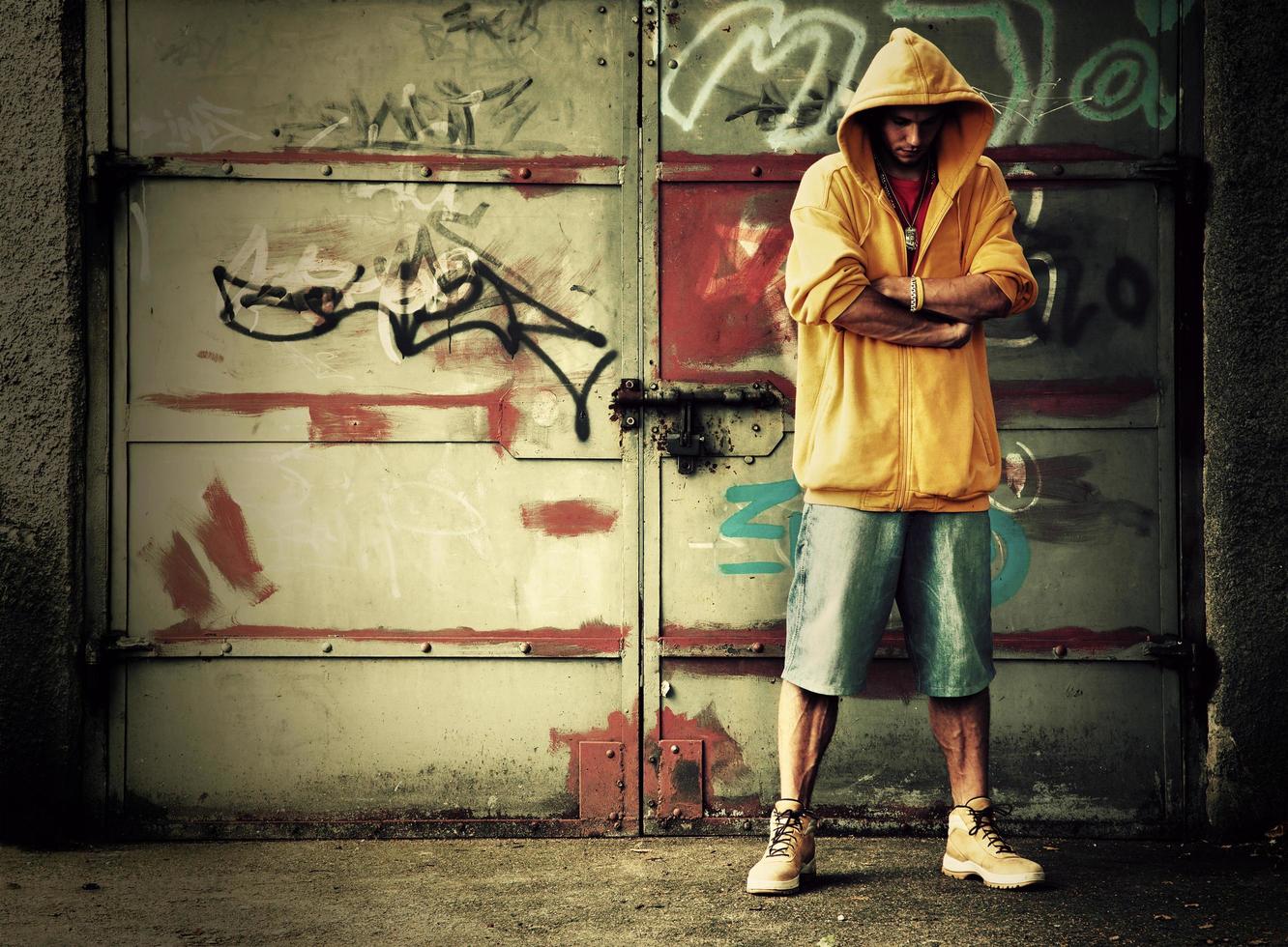 Poland, 2022 - Young man in hooded sweatshirt on grunge wall photo